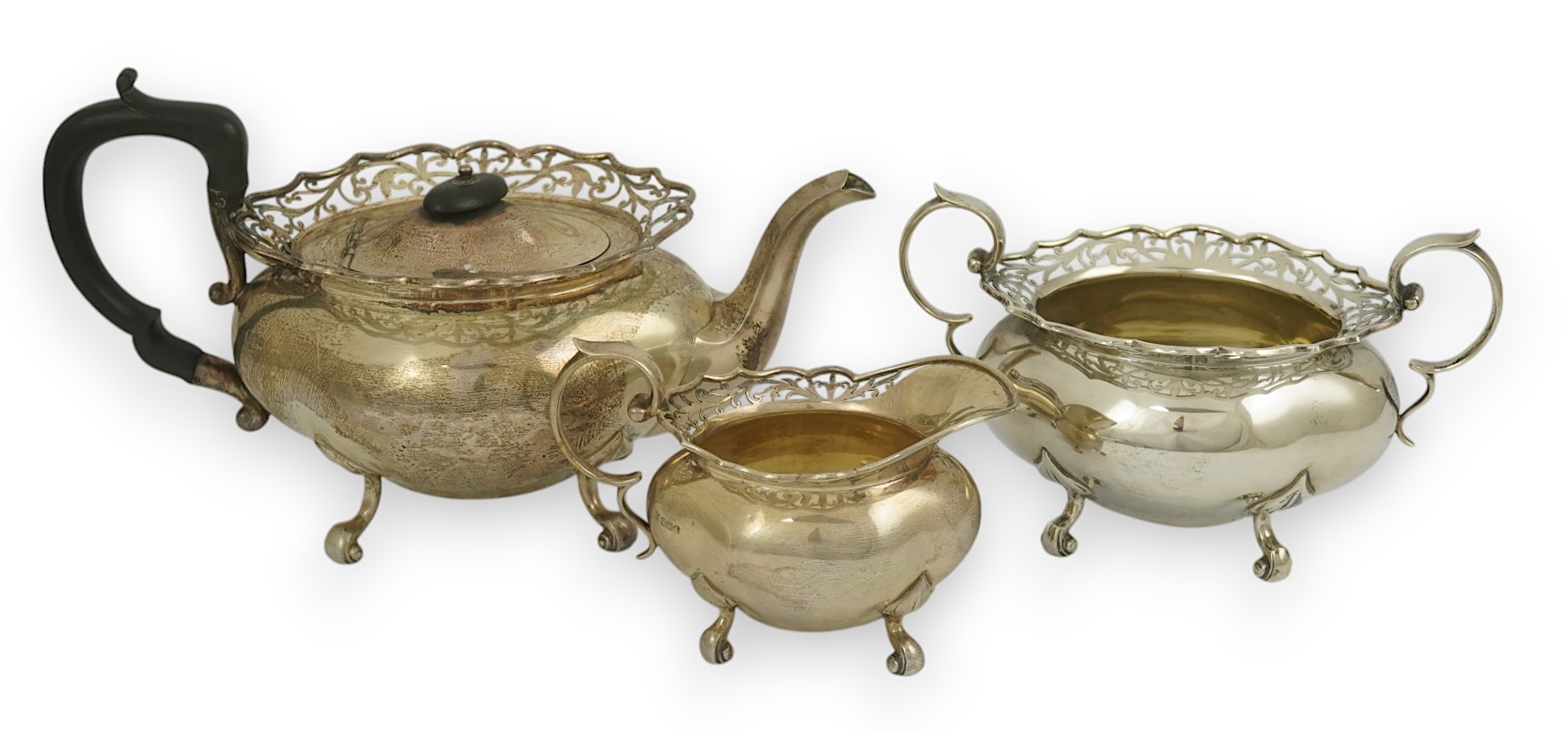 A George V three piece silver circular tea set by James Deakin & Sons